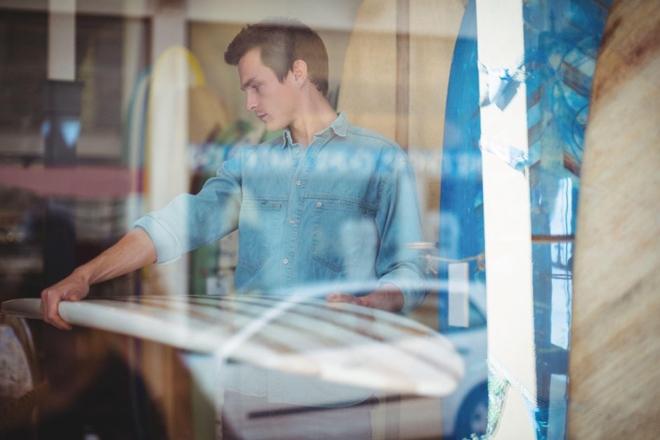 Business owner looking through glass protected with security film for windows inside a commercial property.